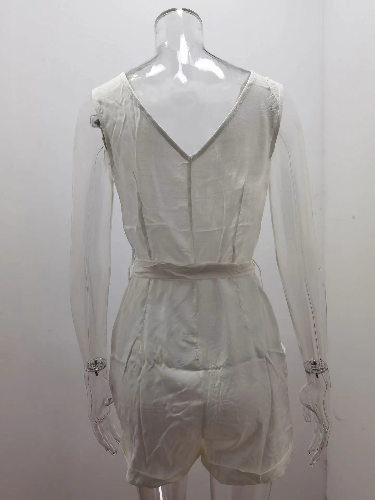 Sheer white romper on a mannequin against a white background